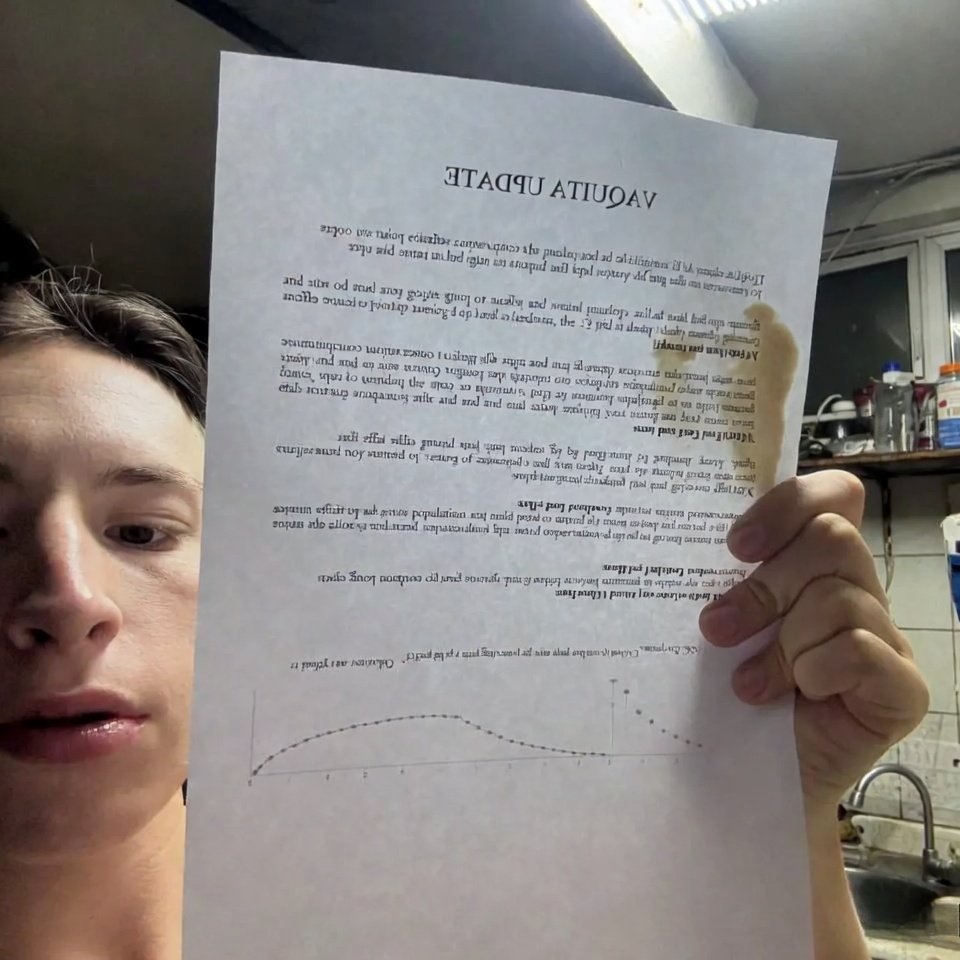 Messy kitchen selfie holding vaquita research paper with coffee stain